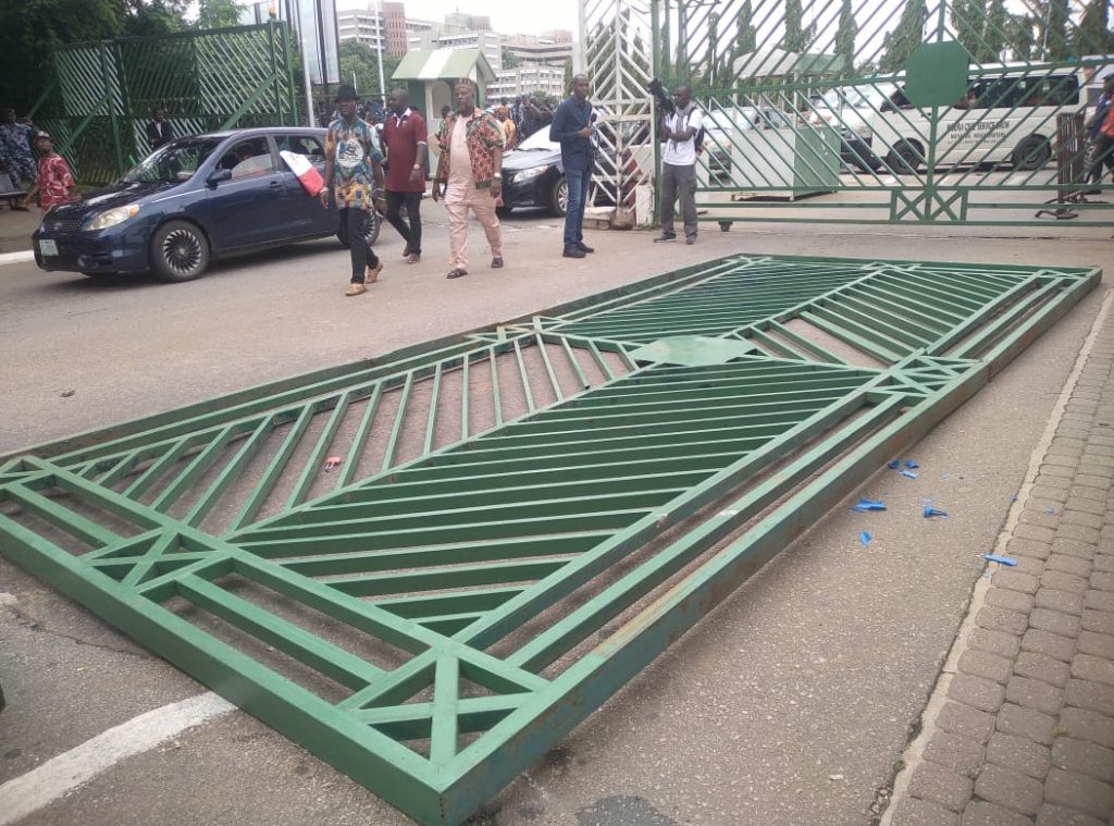 Angry protesters of the Nigerian Labour Congress pull down the gates of ...